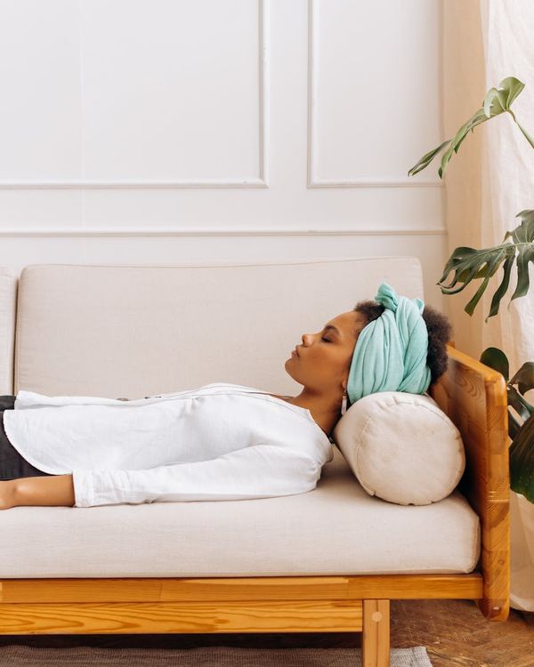 Woman in a calm yoga pose in a softly lit room.
